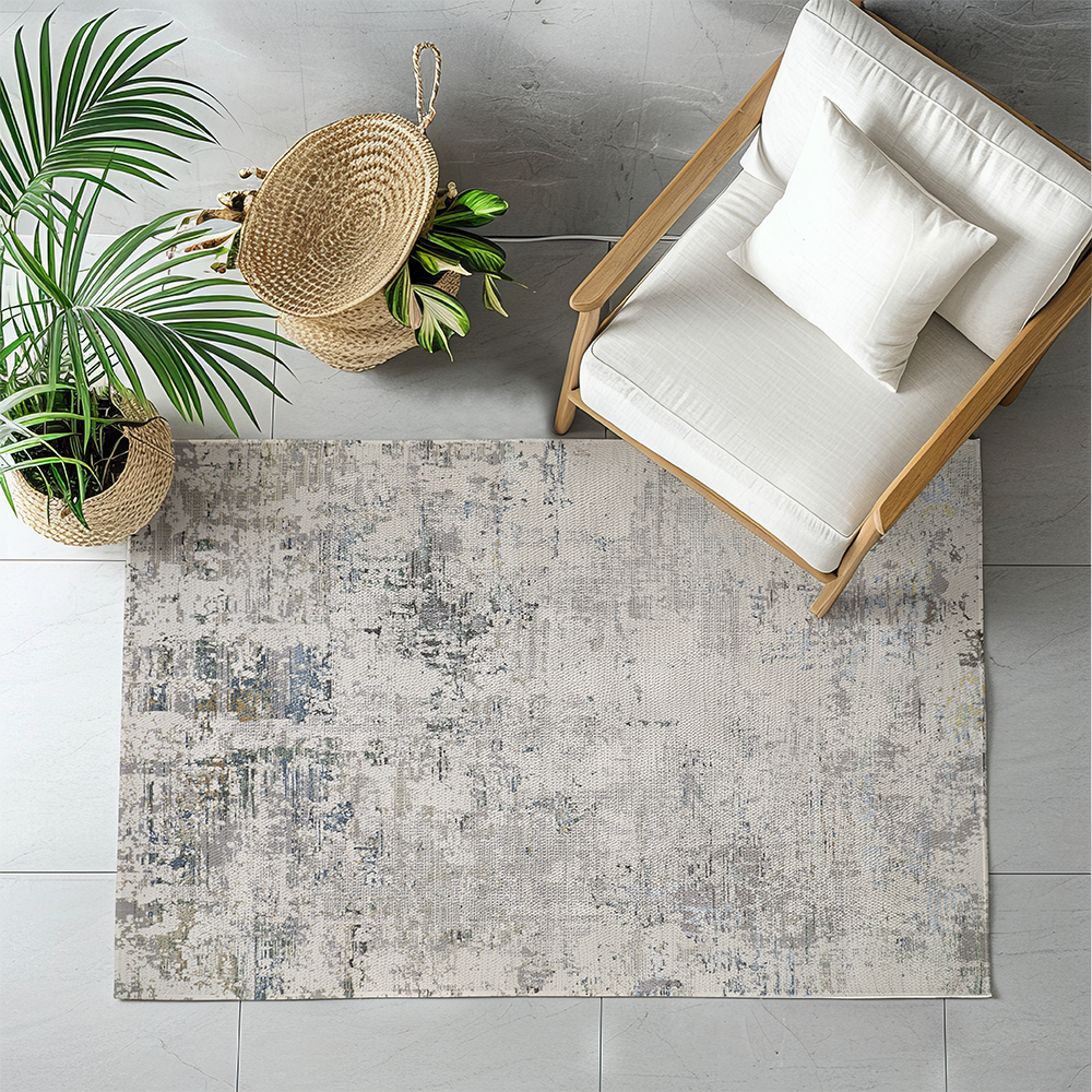Nash abstract textured rug in gray and blue under a chair with plant decor