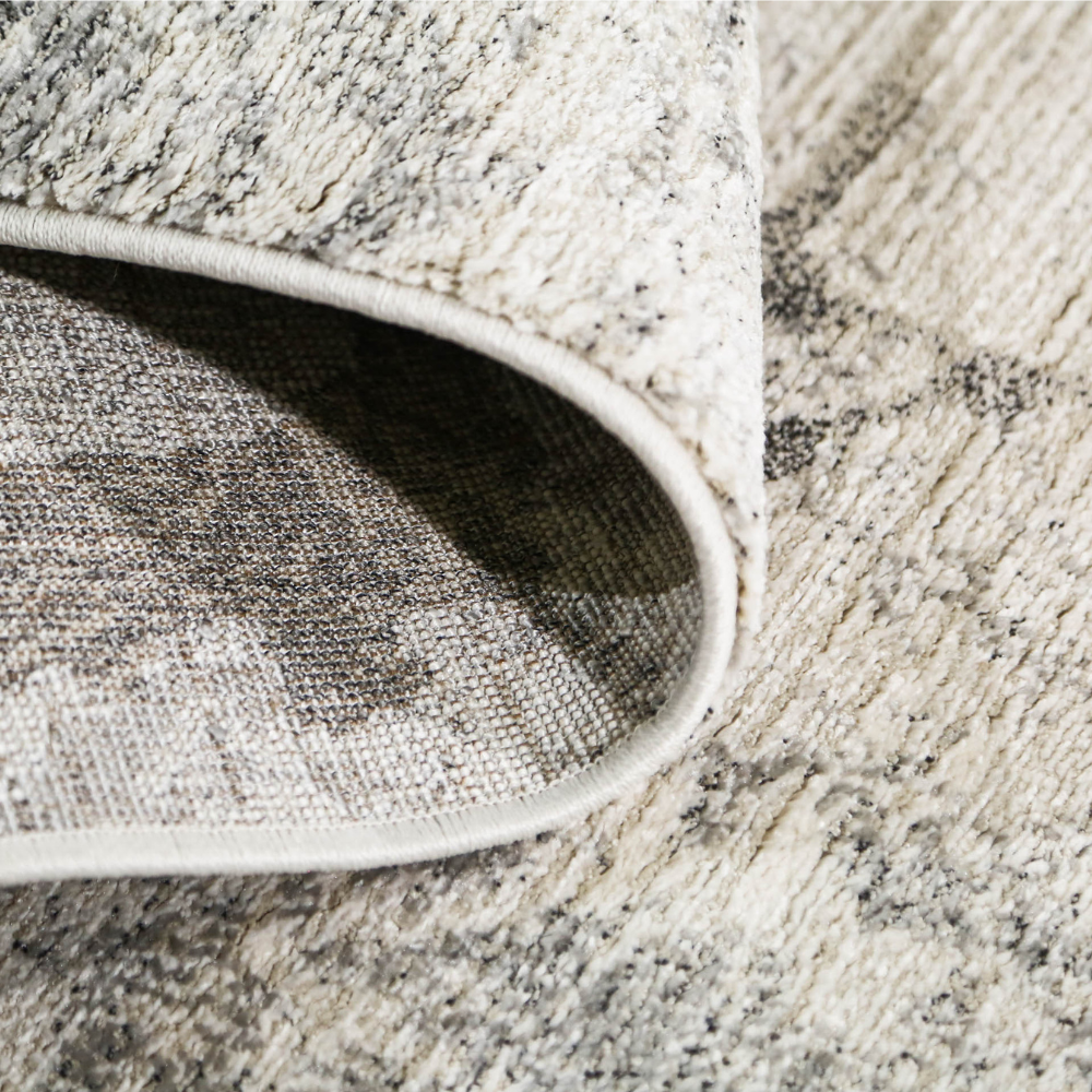 Close-up of Drystan abstract gray and white textured rug with rolled edge